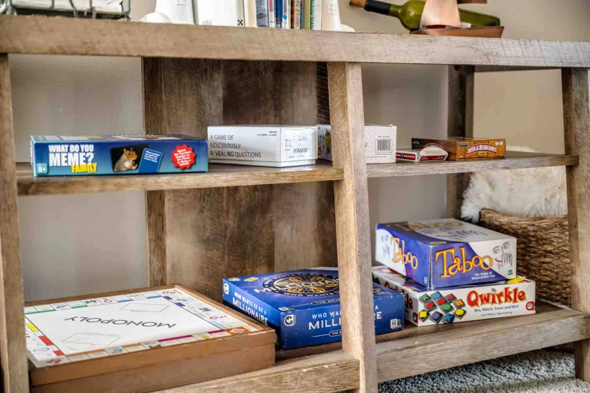 A playful interior featuring a table with board games, a bookshelf filled with books, and cheerful decor, evoking scenes of family game nights or friendly gatherings.